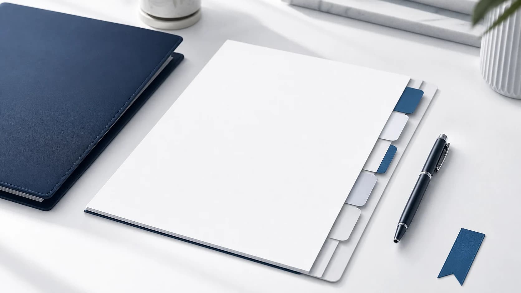Blank engagement packet, navy folder, pen, and signature tabs on a bright white desk